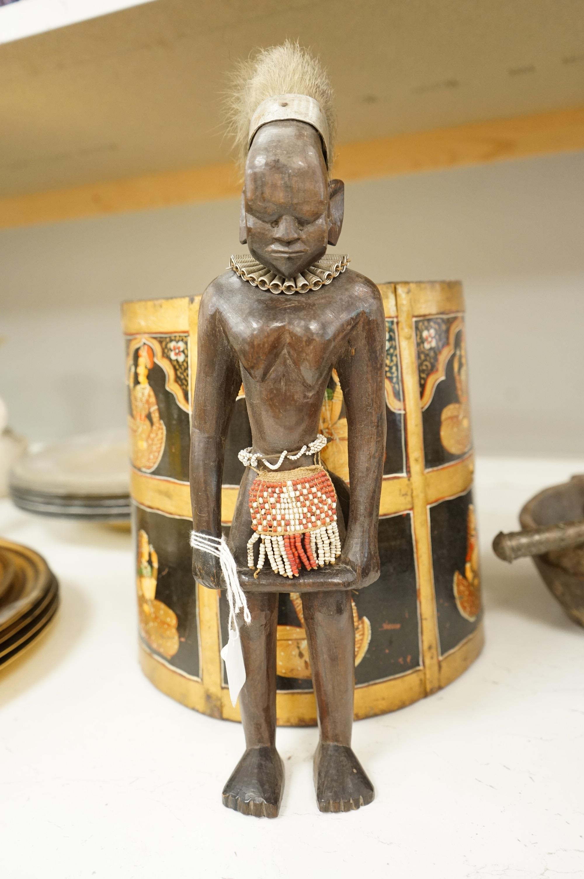 A collection of tribal and Asian collectables including a Tibetan prayer wheel, carvings, etc.